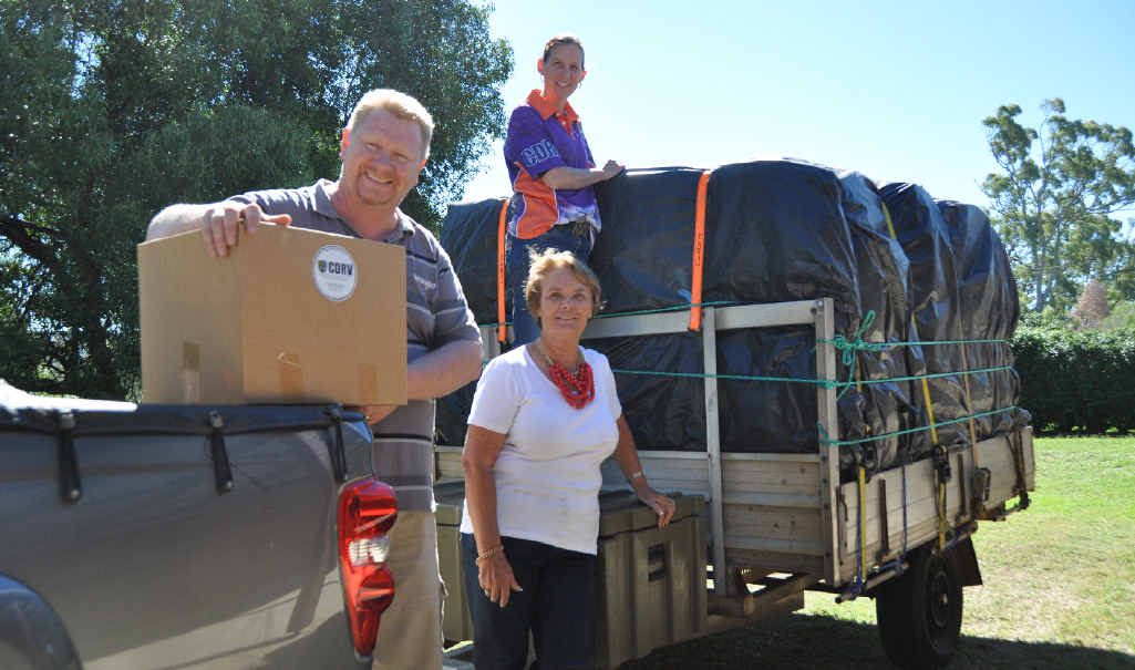 Community Disaster Relief Van board members Brian and Amanda Nothdurft with Longreach resident Sharon Williams packing one of the three loads of supplies heading to the drought-stricken town today.